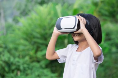 Sanal gerçeklik ile çocuk natrue açık havada arkasında oturan gözlükler.