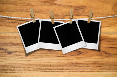 Kırpma yolu ile ahşap arka plan asılı clothespin ile boş fotoğraf çerçevesi.