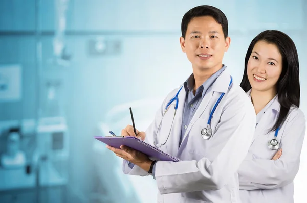 Asian doctors with hearing aid behind the patient room blurred background