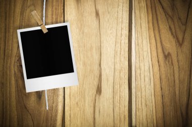 Kırpma yolu ile duvar arka plan asılı clothespin ile boş fotoğraf çerçevesi.