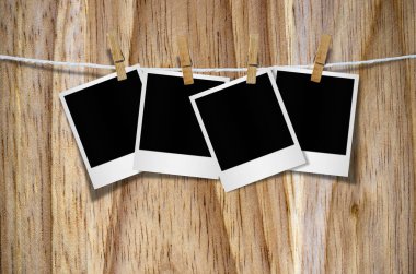 Kırpma yolu ile ahşap arka plan asılı clothespin ile boş fotoğraf çerçevesi.