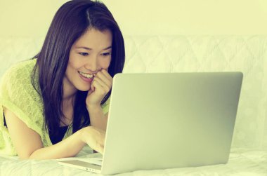 İç, dizüstü bilgisayar kullanarak mutlu genç güzel Asyalı kadın. Vintage tarzı.