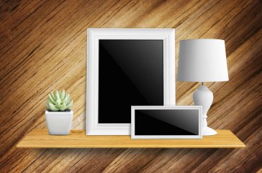 Kitaplık - ürün görüntü için üzerinde yol, lambalar ve saksı kaktüs kırpma ile izole boş resim çerçevesi.