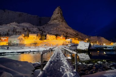 Soğuk bir gecede, karla kaplı ahşap köprüye de Hammarskafte dağa. Reine köyü Norveç.