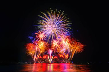 Kara gökyüzü arka planında renkli havai fişekler.