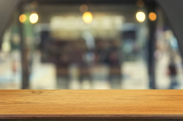 空の木製テーブルとぼやけコーヒー ショップ インテリア背景ボケ画像 製品表示モンタージュをモンタージュのため使用することができますまたは製品を表示 — ストック写真