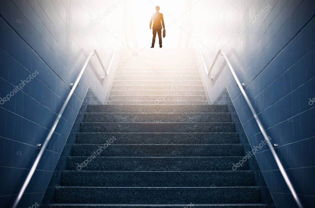 Rear view of a businessman climbing stairs, Concept into success.