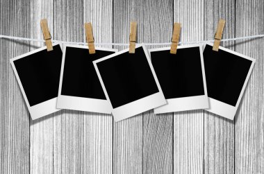 Kırpma yolu ile duvar arka plan asılı clothespin ile boş fotoğraf çerçevesi.