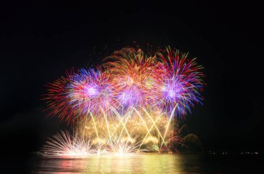 Kara gökyüzü arka planında renkli havai fişekler.