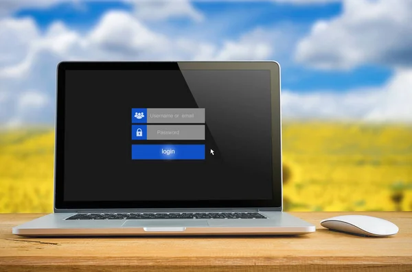 Laptop on table with login on touch screen, login box, user name and password inputs on digital display.