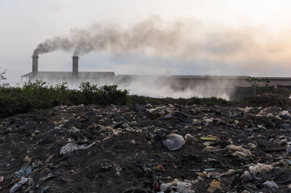 Air pollution with black smoke from chimneys and industrial waste.