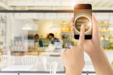 Dokunmatik ekran akıllı telefon kahve simgesini bulanık kahve dükkanı arka plan ile. Kavram Gıda online.