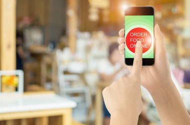 Dokunmatik ekran akıllı telefon kahve simgesini bulanık kahve dükkanı arka plan ile. Kavram Gıda online.