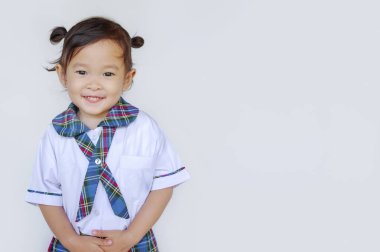 Mutlu sevimli Asya küçük ayakta kopya alanı ile beyaz duvara.