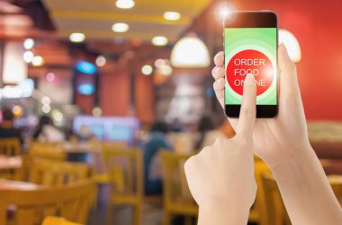 Dokunmatik ekran akıllı telefon kahve simgesini bulanık kahve dükkanı arka plan ile. Kavram Gıda online.