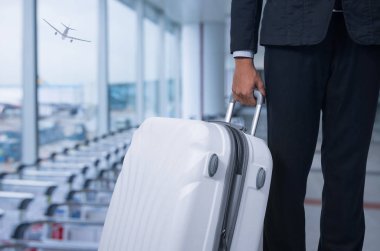 İşadamı ve bavul Havaalanı kalkış salonu, uçağın arka plan bulanık, yaz tatil kavramı, seyahat bavul Havaalanı terminal bekleyen alan içinde. .