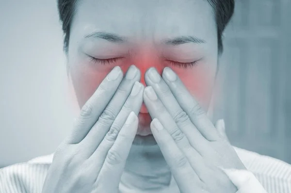 Female patients with nose pain in the hospital room.