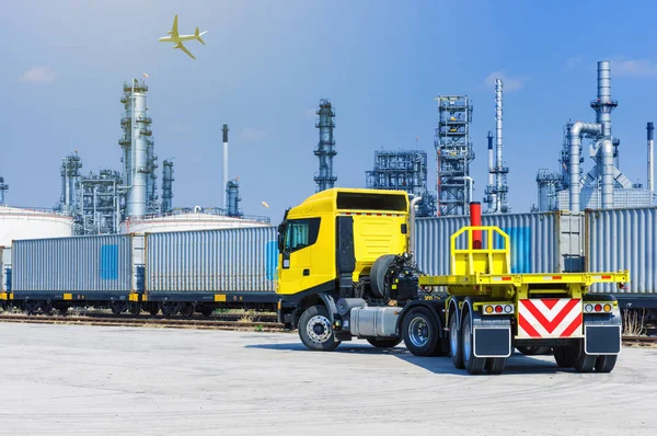 Trucks and containers on rail against the backdrop of the refinery, Industrial and transportation concept.