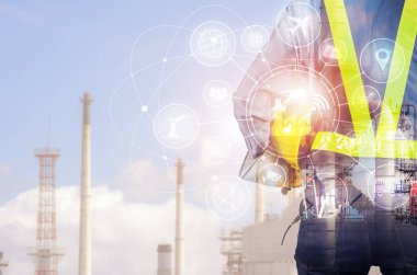 İşçiler, bulanık petrol rafinerisi arka plan, sanayi 4.0 konsept güvenliği için sarı kask tutarak aşırı aracıyla mühendisi çift pozlama.