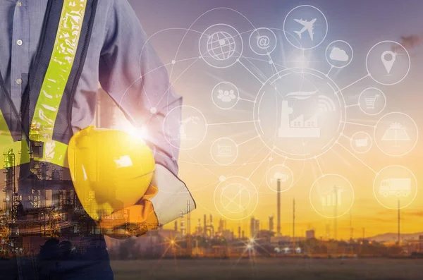 İşçiler, bulanık petrol rafinerisi arka plan, sanayi 4.0 konsept güvenliği için sarı bir kask tutan mühendisi çift pozlama.