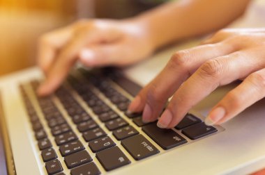 Eller serbest kadın'ın bir kafede klavye dizüstü bilgisayarda yazarak, web arama, tarama / yumuşak odak görüntü dizüstü kullanan kız.