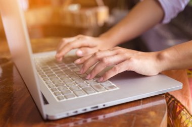 Eller serbest kadın'ın bir kafede klavye dizüstü bilgisayarda yazarak, web arama, tarama / yumuşak odak görüntü dizüstü kullanan kız.