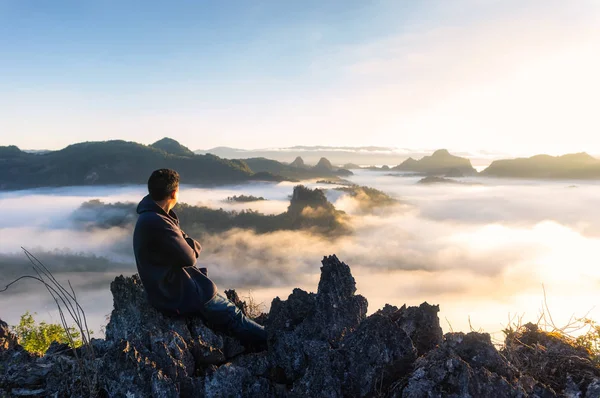 Tyłu Mężczyzna Siedzi Szczycie Góry Oglądanie Mgły Dmuchanie Przez Góry — Zdjęcie stockowe