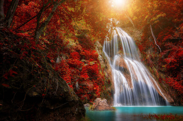Waterfall in tropical deep forest with autumn color change Beautiful nature, Thailand.