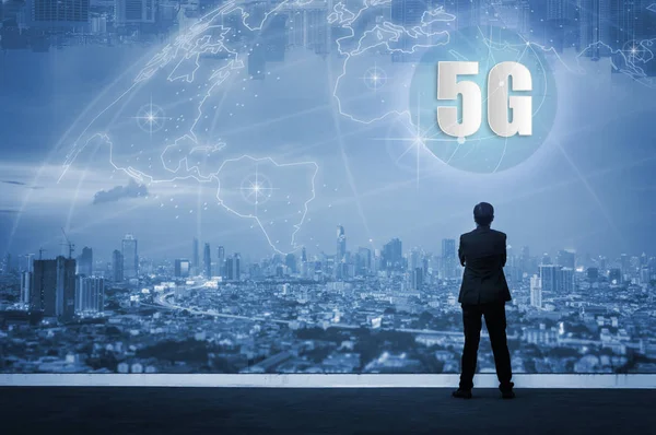5g ağ kablosuz sistemleri ve şeylerin üstüne Bina Cityscape manzarası gece lambası, Bağlan global kablosuz cihazlar seyir ayakta başarılı iş adamı ile Internet.