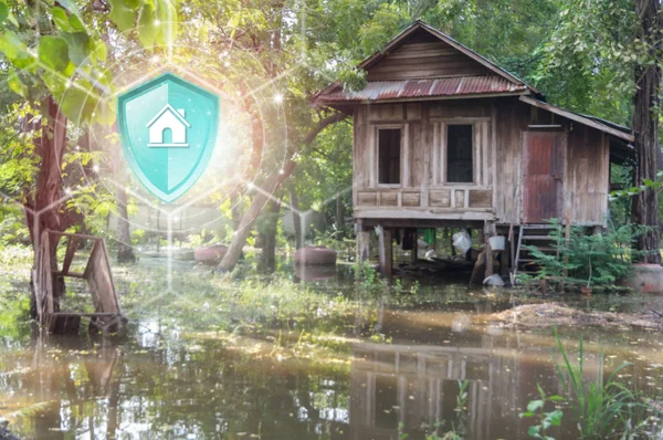 Property insurance, Shield protection Property on virtual screen against Old wooden house with flood on backdrop, Concept of insurance, Online insurance digital technology.