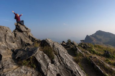 Dağ, güzel görünüm noktası Doi Pha Tang, Chiang Rai'nın gizli cennet, Tayland, seyahat yerin üstündeki oturan kadın turist.