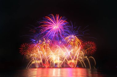 Kara gökyüzü arka planında renkli havai fişekler.