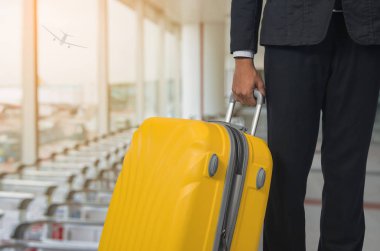 İşadamı ve kalkış salonu havaalanında bavul, uçağın arka plan bulanık, yaz tatil kavramı, seyahat bavul Havaalanı terminal bekleyen alan içinde 