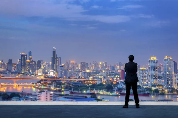 视觉概念 成功的商人站在手交叉在胸部 在建筑物的顶部和通过城市景观天际线夜景灯光 — 图库照片