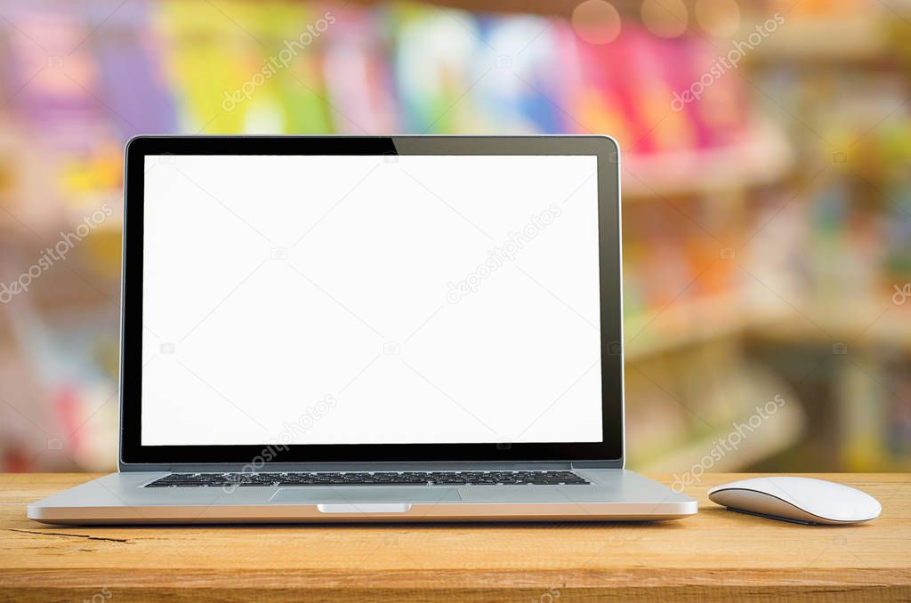Conceptual workspace, Laptop with blank screen on table with bookshelf blurred background.