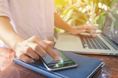 yazarak arama, tarama web dizüstü kullanan kız klavye Laptop ile smartphone, bir kafede WOMANS eller 