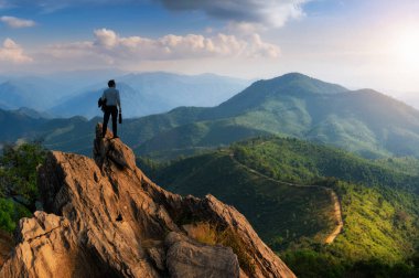 Kavram görme, genç işadamı giyiyor rahat rahat takım elbise ceket ayakta iş ihale en yüksek dağın tepesinde ve ileriye bakarak, başarı, rekabet ve lider kavramı.