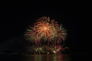 Kara gökyüzü arka planında renkli havai fişekler.