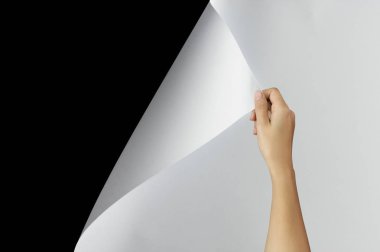 Woman hand turning page of paper, Blank sheet of paper on black background with clipping path. Change concept. clipart