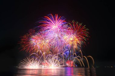 Kara gökyüzü arka planında renkli havai fişekler.