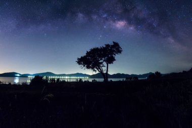 Yıldızlar ve Pranburi baraj, batısında Hua Hin ağacında yukarıda univers Uzay tozu ile Samanyolu.