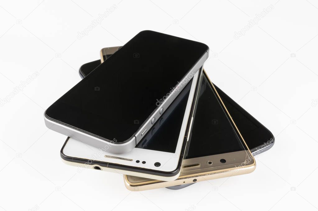 Stack of high-end smartphones on white desk.
