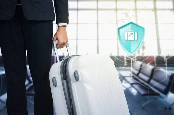 Travel Insurance, Shield protection Travel on virtual screen against Businessman and suitcase in the airport on backdrop, Concept of insurance, Online insurance digital technology.