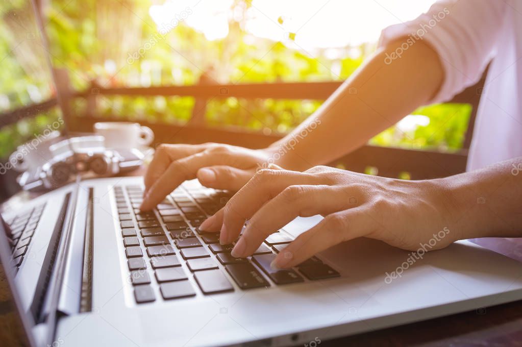 Freelance hands on the keyboard of laptop in a cafe, girl using laptop typing, web searching