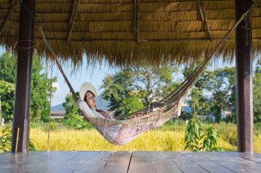 Genç kız hamak sabah Resort'ta asılı iken rahatlatıcı.