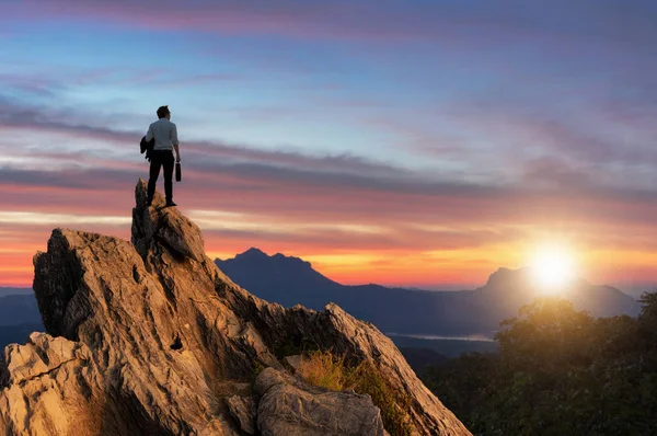 コンセプト ビジョン 快適なカジュアルなスーツ ビジネス バッグ ピーク山の頂上に立って 転送を探して 競争とリーダーの概念を身に着けている青年実業家 — ストック写真