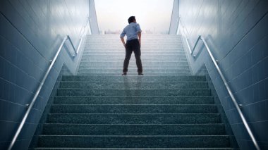 Businessman climbed on top of the stairs going to the city,  Ambitions concept and Success business. clipart