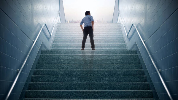 Businessman climbed on top of the stairs going to the city,  Ambitions concept and Success business.