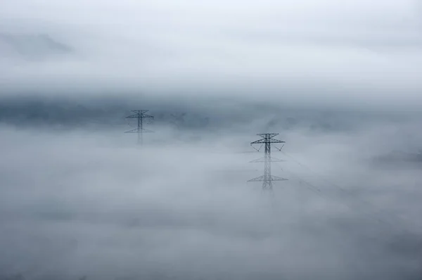 Torres de transmissão elétrica em nevoeiro — Fotografia de Stock