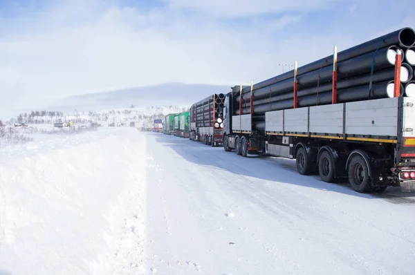 Trucks on Arctic road in gloomy weather in Norway, Logistics concept